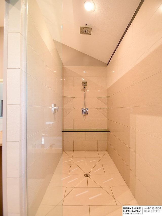 6535 N 157th St, Omaha, NE 68116 - bathroom featuring tiled shower, vaulted ceiling, and tile patterned floors