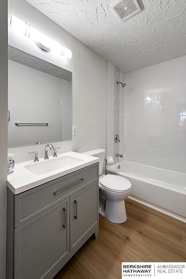 7025 S 41st St, Bellevue, NE 68147 - full bathroom with wood finished floors, vanity, a textured ceiling, and shower / bath combination