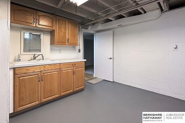7025 S 41st St, Bellevue, NE 68147 - kitchen with finished concrete floors, light countertops, brown cabinetry, and concrete block wall