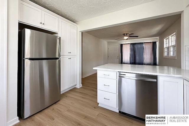 7025 S 41st St, Bellevue, NE 68147 - kitchen with stainless steel appliances, white cabinetry, light wood finished floors, a peninsula, and a ceiling fan
