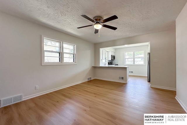 7025 S 41st St, Bellevue, NE 68147 - spare room featuring light wood-style flooring, a ceiling fan, and a textured ceiling