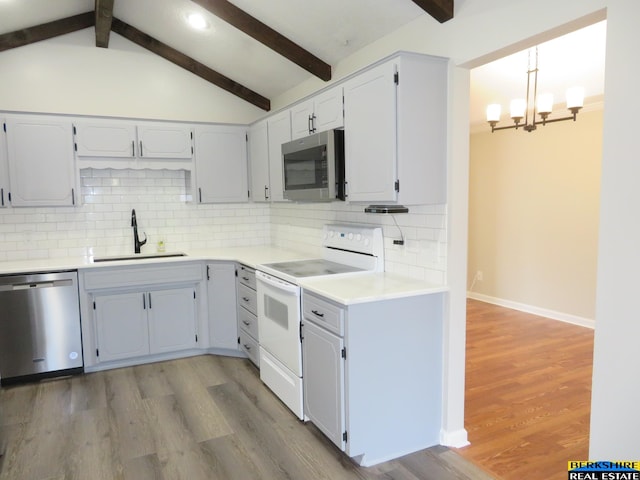 933 N 150th St, Omaha, NE 68154 - kitchen with appliances with stainless steel finishes, a chandelier, decorative backsplash, light wood-style floors, and light countertops