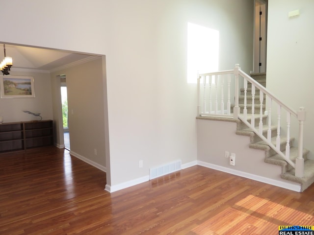 933 N 150th St, Omaha, NE 68154 - unfurnished living room with ornamental molding, wood finished floors, a chandelier, and stairs