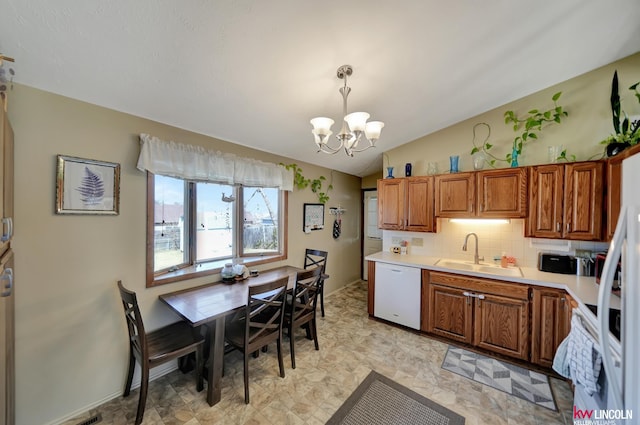 8032 E Avon Ln, Lincoln, NE 68505 - kitchen featuring white appliances, a chandelier, brown cabinetry, light countertops, and tasteful backsplash