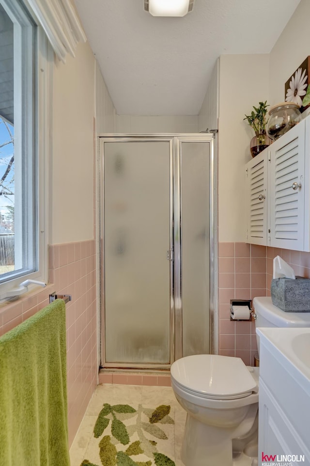 8032 E Avon Ln, Lincoln, NE 68505 - full bath featuring tile walls, a stall shower, vanity, tile patterned flooring, and a wainscoted wall