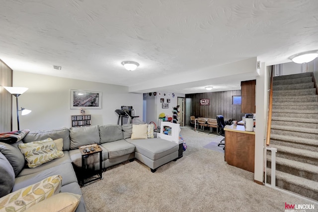 8032 E Avon Ln, Lincoln, NE 68505 - living room with stairway, carpet flooring, wooden walls, and a textured ceiling