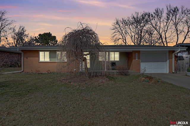 8032 E Avon Ln, Lincoln, NE 68505 - view of front facade with a garage, brick siding, a front lawn, and driveway