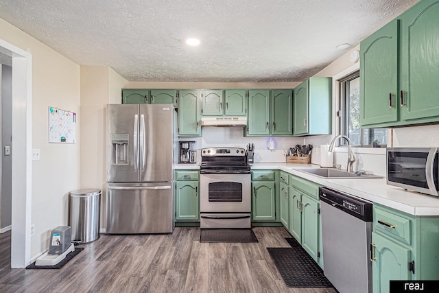 549 Washtington St, Carson, IA 51525 - kitchen with appliances with stainless steel finishes, under cabinet range hood, green cabinetry, a textured ceiling, and recessed lighting
