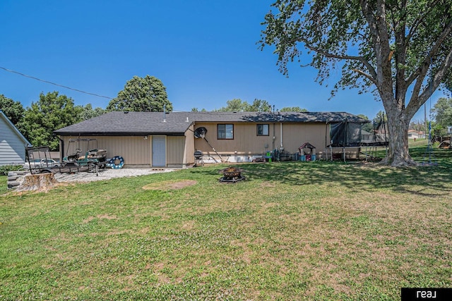 549 Washtington St, Carson, IA 51525 - rear view of property featuring a trampoline, an outdoor fire pit, a patio area, and a yard