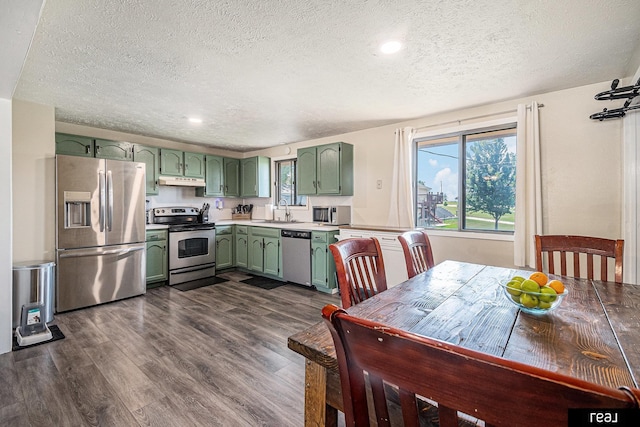 549 Washtington St, Carson, IA 51525 - kitchen featuring green cabinetry, appliances with stainless steel finishes, a textured ceiling, under cabinet range hood, and light countertops