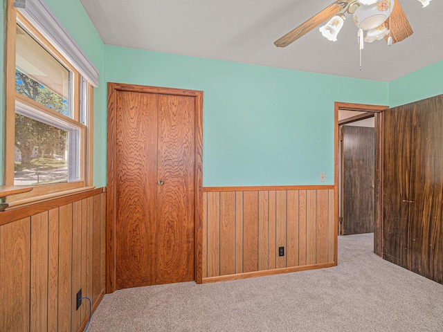 9418 Meredith Ave, Omaha, NE 68134 - bedroom featuring wood walls, wainscoting, carpet flooring, and ceiling fan