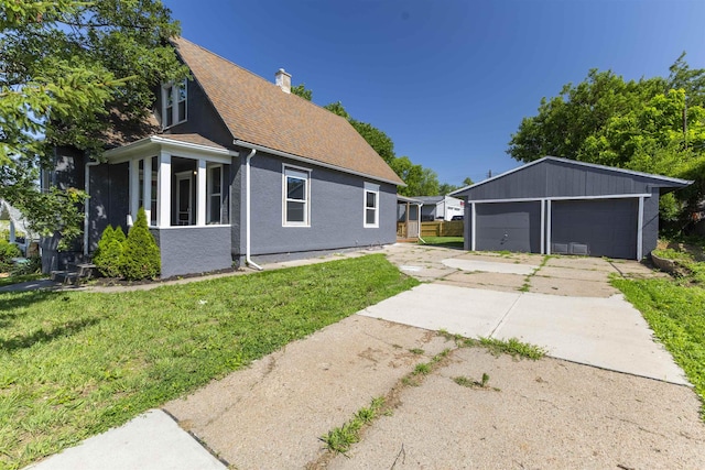 6316 Spencer St, Omaha, NE 68104 - view of side of property with a detached garage, a yard, a chimney, an outbuilding, and a shingled roof