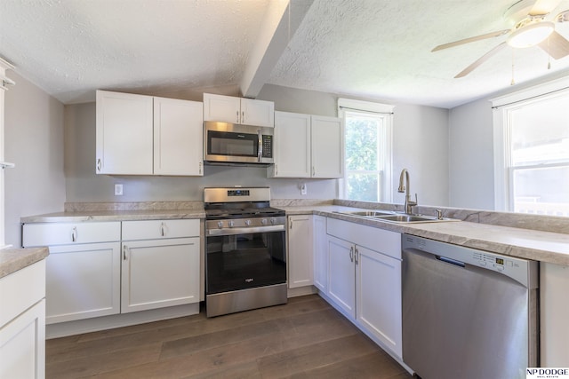 6316 Spencer St, Omaha, NE 68104 - kitchen featuring appliances with stainless steel finishes, white cabinetry, dark wood-style flooring, a textured ceiling, and a ceiling fan