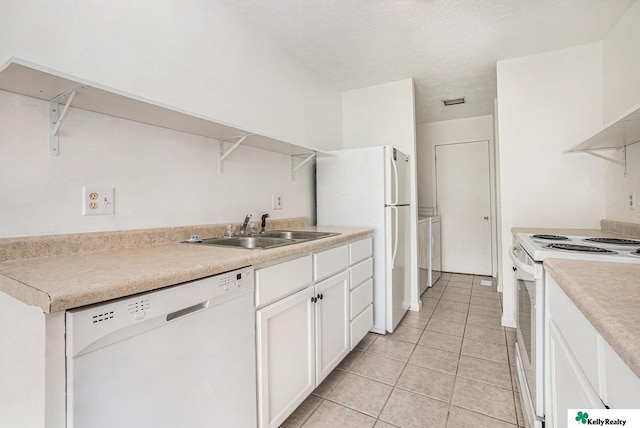 13229 Glenn St, Omaha, NE 68138 - kitchen featuring white appliances, light tile patterned flooring, white cabinets, washer / dryer, and light countertops