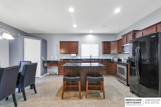 14210 Potter Pkwy, Omaha, NE 68142 - kitchen featuring stainless steel appliances, dark countertops, a center island, a kitchen bar, and recessed lighting