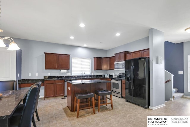 14210 Potter Pkwy, Omaha, NE 68142 - kitchen featuring stainless steel appliances, dark countertops, a kitchen island, a breakfast bar, and recessed lighting