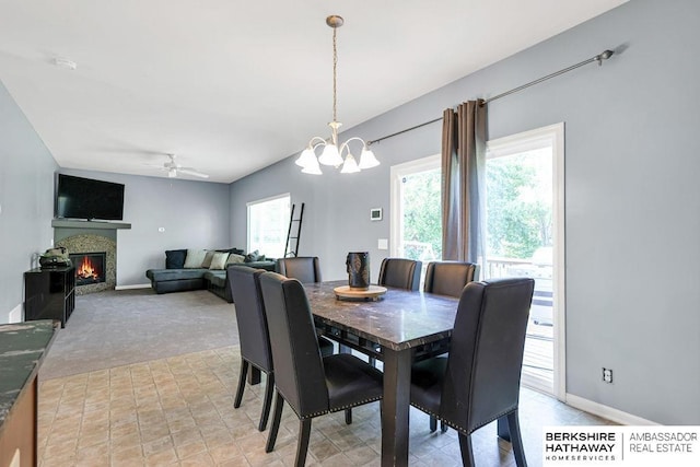 14210 Potter Pkwy, Omaha, NE 68142 - dining area featuring a ceiling fan, a chandelier, a lit fireplace, and light colored carpet