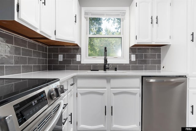 12529 C St, Omaha, NE 68144 - kitchen featuring stainless steel appliances, white cabinetry, and tasteful backsplash
