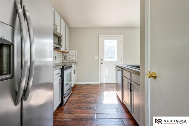6961 N 89th Ave, Omaha, NE 68122 - kitchen featuring appliances with stainless steel finishes, dark wood-style floors, tasteful backsplash, and light stone countertops