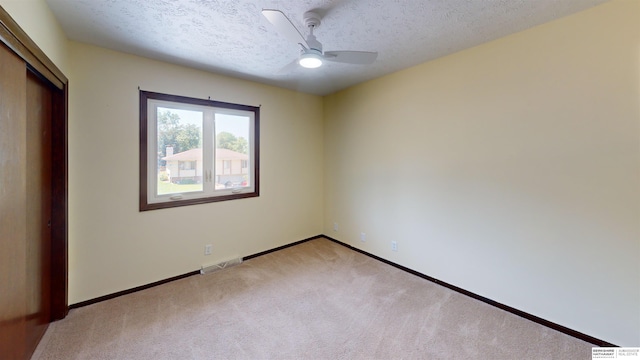 10912 V St, Omaha, NE 68137 - unfurnished bedroom featuring light carpet, a textured ceiling, a closet, and ceiling fan