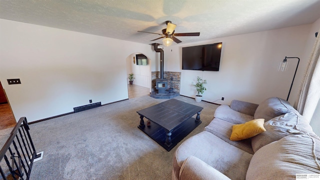 10912 V St, Omaha, NE 68137 - carpeted living room with a wood stove, ceiling fan, and arched walkways