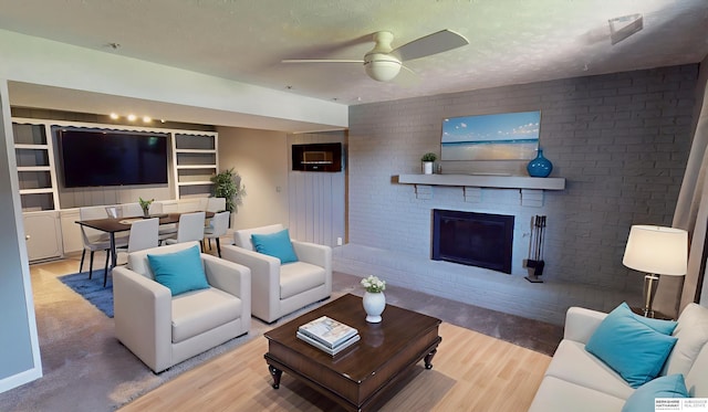10912 V St, Omaha, NE 68137 - living area featuring wood finished floors, ceiling fan, brick wall, a brick fireplace, and a textured ceiling