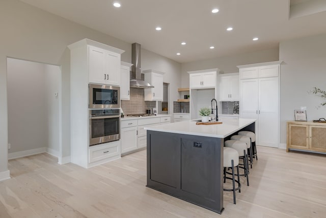 5608 N 212th St, Elkhorn, NE 68022 - kitchen with appliances with stainless steel finishes, wall chimney range hood, decorative backsplash, light wood finished floors, and recessed lighting