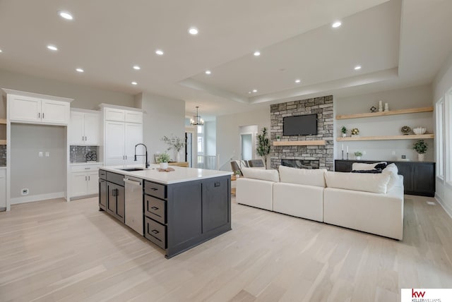 5608 N 212th St, Elkhorn, NE 68022 - kitchen with white cabinets, dishwasher, a raised ceiling, light wood-type flooring, and an island with sink