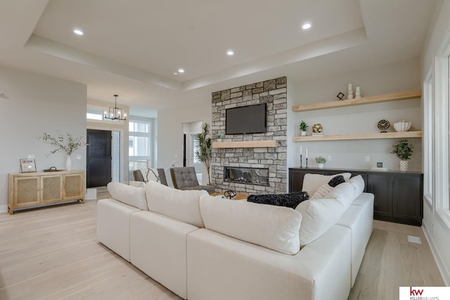 5608 N 212th St, Elkhorn, NE 68022 - living room featuring a tray ceiling, light wood-style floors, a fireplace, recessed lighting, and a dry bar