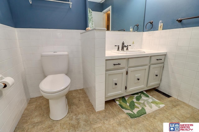 5951 Oakridge Dr, Lincoln, NE 68516 - bathroom with tile walls, vanity, tile patterned flooring, and wainscoting