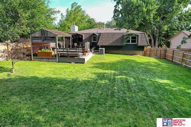 5951 Oakridge Dr, Lincoln, NE 68516 - back of property with a chimney, a shingled roof, a fenced backyard, and a wooden deck