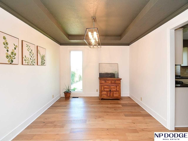 724 N 155th Ave, Omaha, NE 68154 - unfurnished dining area featuring a raised ceiling, light wood-type flooring, a chandelier, and a textured ceiling