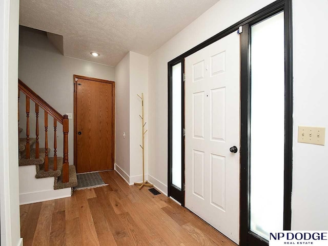 724 N 155th Ave, Omaha, NE 68154 - entrance foyer with light wood-style floors, a textured ceiling, and stairs