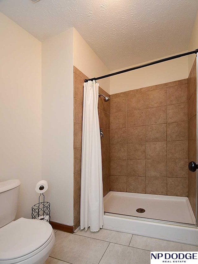 724 N 155th Ave, Omaha, NE 68154 - full bath featuring tile patterned flooring, a shower stall, and a textured ceiling