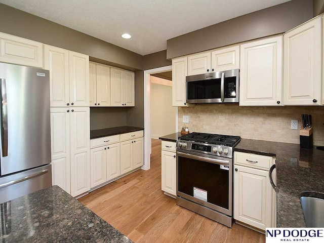 724 N 155th Ave, Omaha, NE 68154 - kitchen featuring appliances with stainless steel finishes, light wood finished floors, backsplash, white cabinets, and recessed lighting