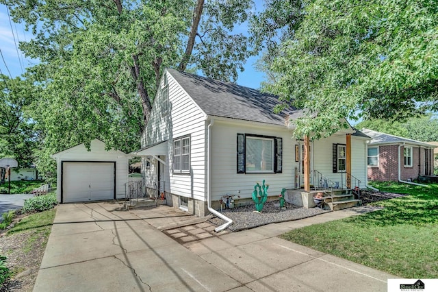 4415 S St, Lincoln, NE 68506 - view of front of house featuring concrete driveway, a shingled roof, a garage, an outbuilding, and a front yard