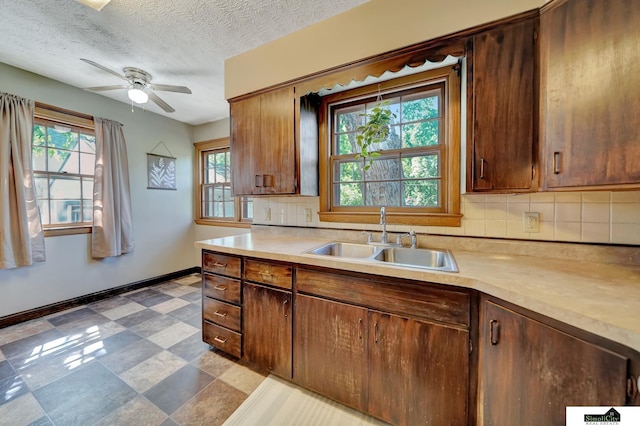 4415 S St, Lincoln, NE 68506 - kitchen featuring light countertops, tasteful backsplash, ceiling fan, a textured ceiling, and tile patterned floors