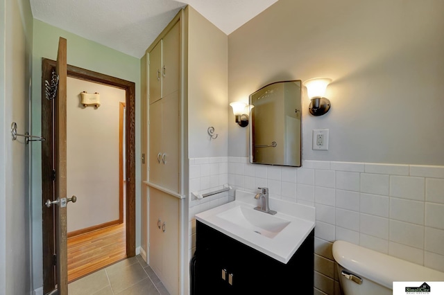 4415 S St, Lincoln, NE 68506 - bathroom featuring vanity, tile patterned floors, tile walls, and wainscoting