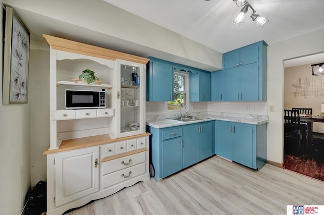 6336 N 37th St, Omaha, NE 68111 - kitchen with blue cabinets, light countertops, light wood-type flooring, and open shelves