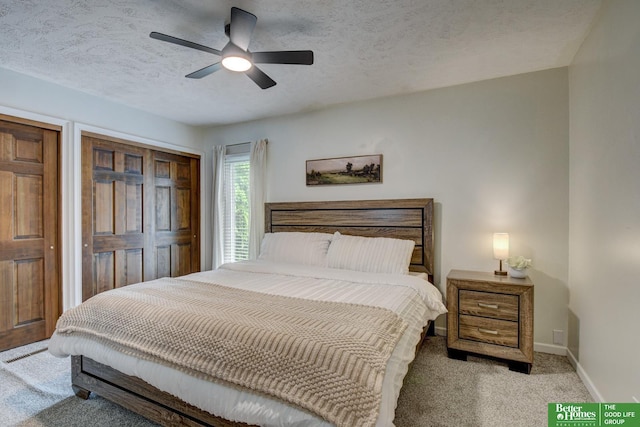 11122 Jefferson St, Omaha, NE 68137 - bedroom featuring light carpet, a textured ceiling, a ceiling fan, and multiple closets