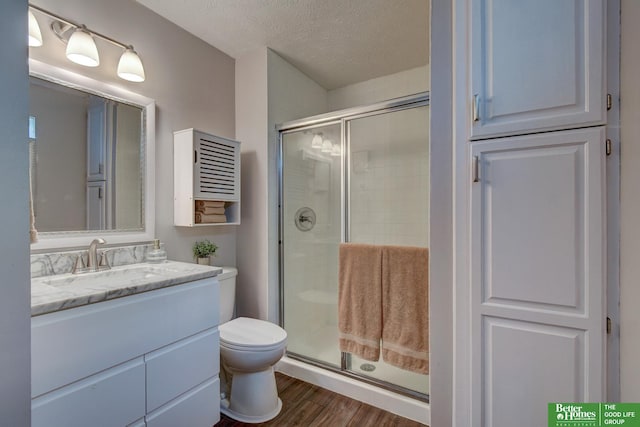 11122 Jefferson St, Omaha, NE 68137 - bathroom with a shower stall, vanity, wood finished floors, and a textured ceiling