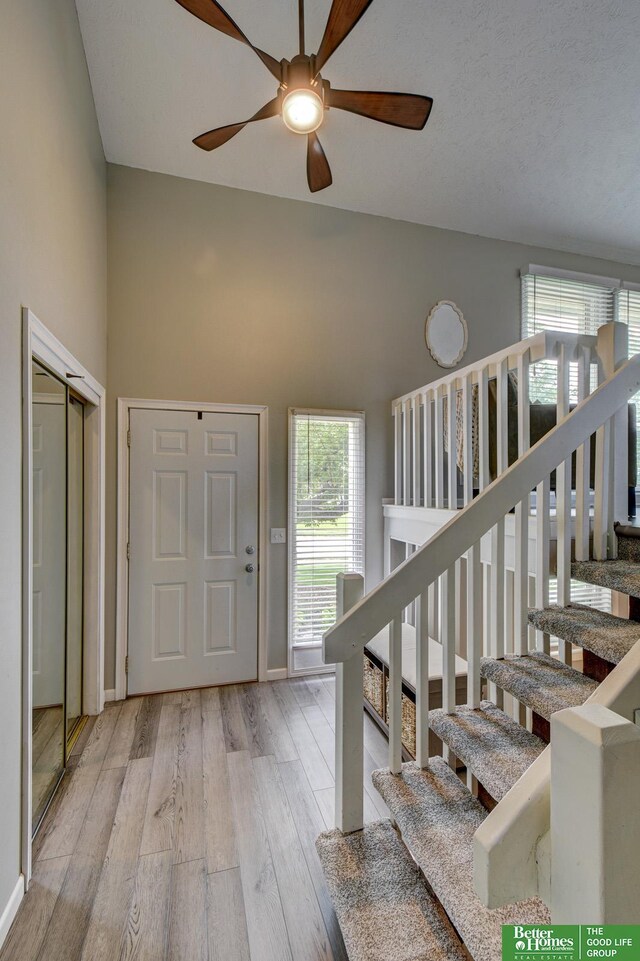 11122 Jefferson St, Omaha, NE 68137 - entryway featuring a ceiling fan, light wood-style floors, stairs, and a towering ceiling