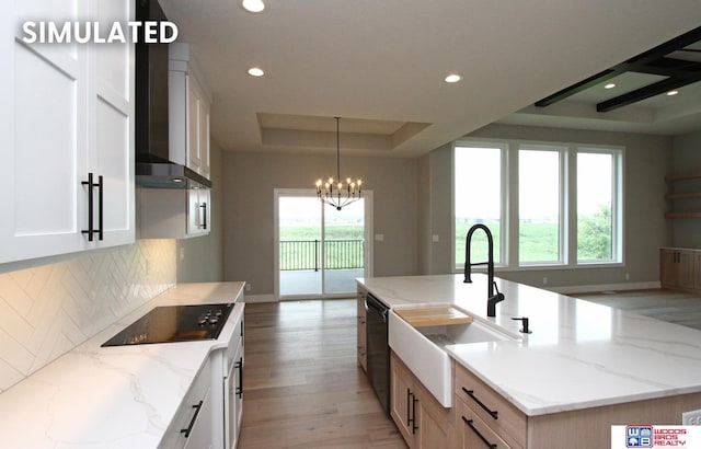 941 N 104th St, Lincoln, NE 68527 - kitchen featuring a raised ceiling, wall chimney exhaust hood, black appliances, backsplash, and a chandelier