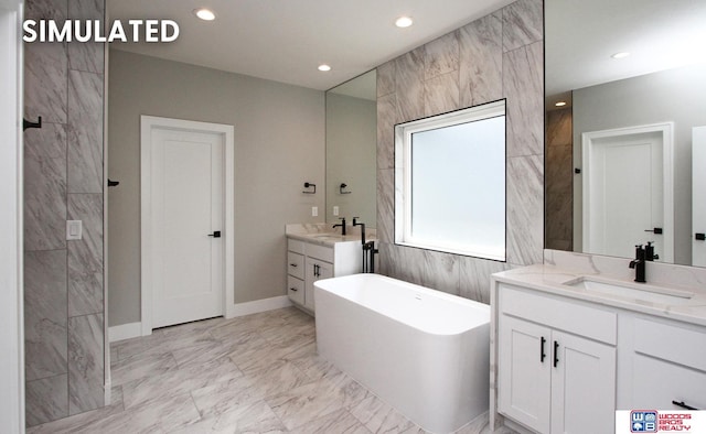 941 N 104th St, Lincoln, NE 68527 - bathroom featuring marble look tile flooring, a freestanding tub, two vanities, and recessed lighting