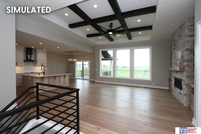 941 N 104th St, Lincoln, NE 68527 - unfurnished living room featuring coffered ceiling, a chandelier, a stone fireplace, beamed ceiling, and light wood-type flooring