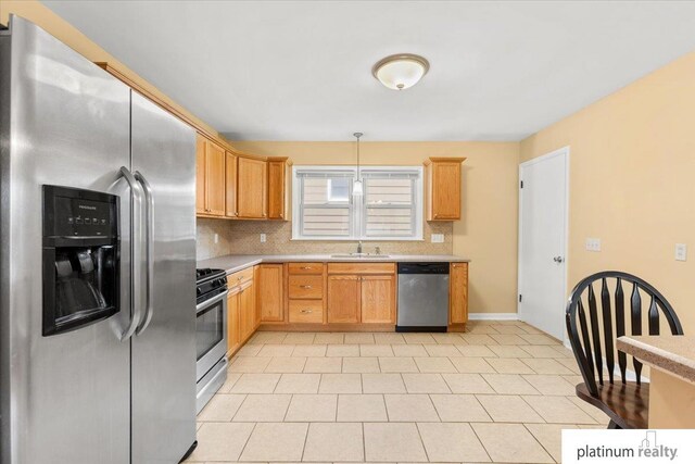 3052 S 46th Ave, Omaha, NE 68106 - kitchen with stainless steel appliances, light countertops, backsplash, and decorative light fixtures