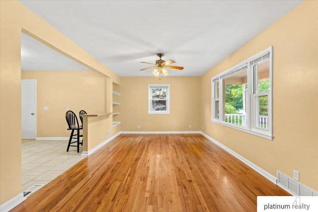 3052 S 46th Ave, Omaha, NE 68106 - unfurnished living room with plenty of natural light, a ceiling fan, and wood finished floors