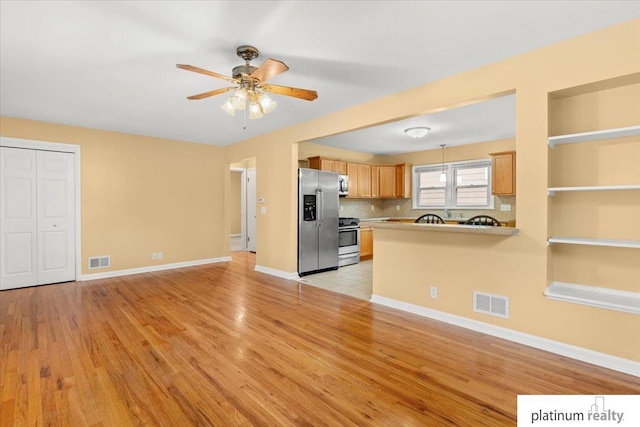 3052 S 46th Ave, Omaha, NE 68106 - kitchen featuring stainless steel appliances, open floor plan, ceiling fan, light wood-style floors, and a peninsula