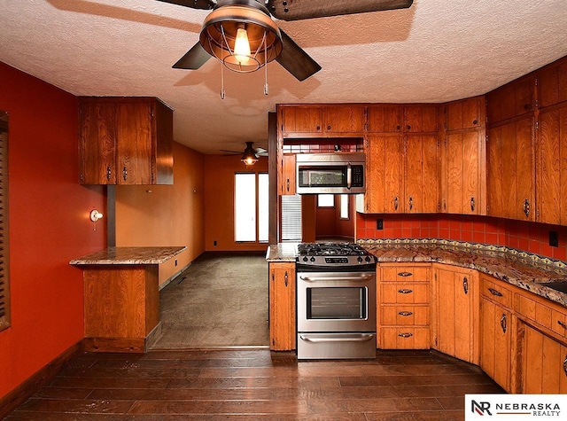7626 S 41st St, Bellevue, NE 68147 - kitchen with stainless steel appliances, ceiling fan, brown cabinetry, dark wood finished floors, and a textured ceiling
