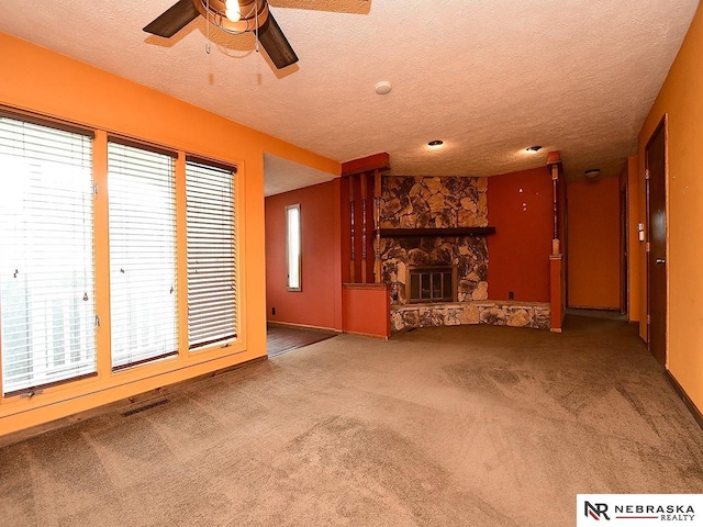 7626 S 41st St, Bellevue, NE 68147 - unfurnished living room with a fireplace, a ceiling fan, carpet, a textured ceiling, and plenty of natural light